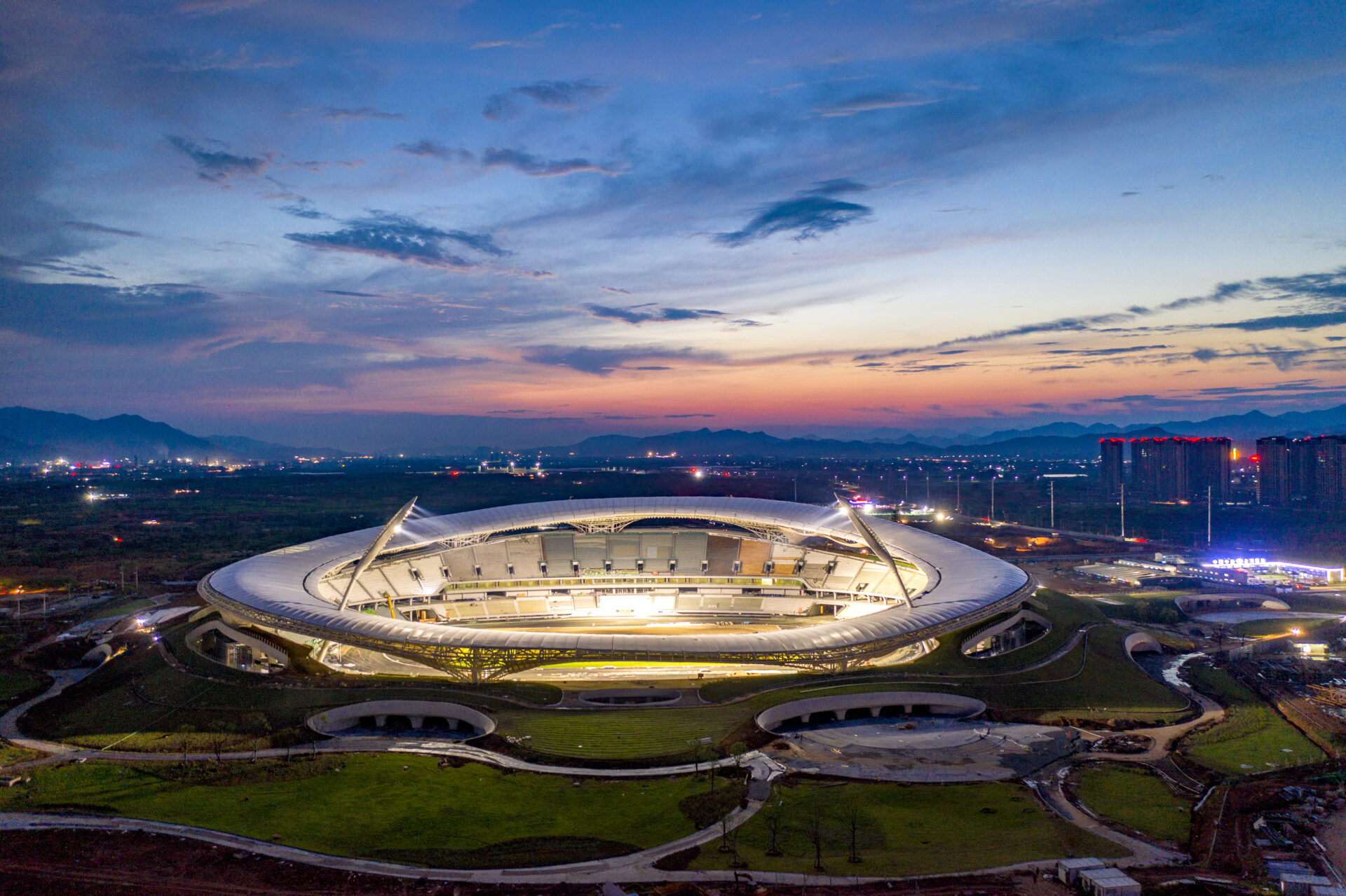 Vue aérienne nocturne du Quzhou Stadium éclairé avec toiture textile circulaire Serge Ferrari