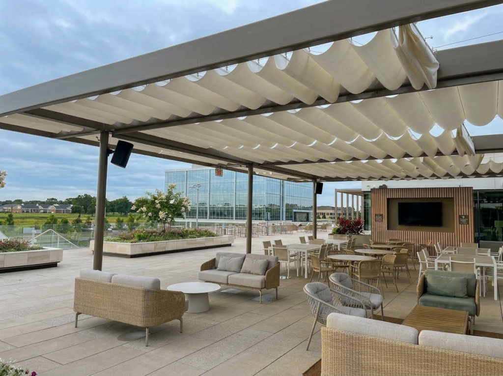 Modern outdoor lounge with retractable fabric canopy, seating area, and landscaped terrace.
