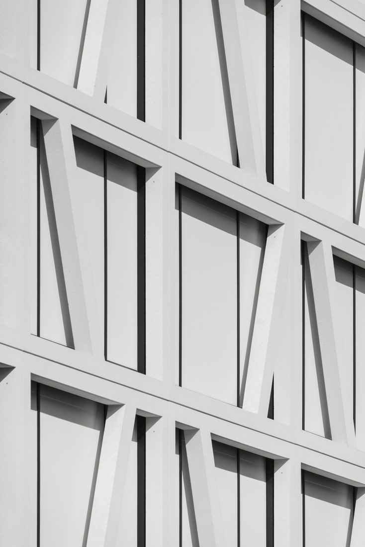 Façade blanche avec structure diagonale et panneaux pleins.