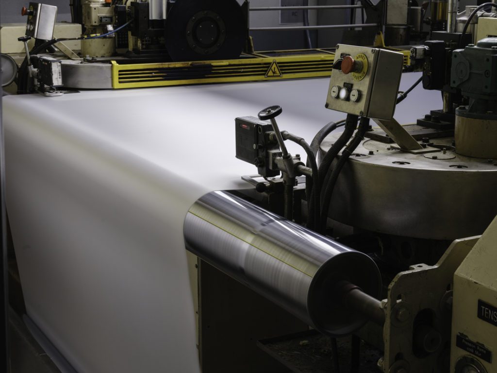 Machine industrielle de production de toile en fonctionnement dans une usine Serge Ferrari