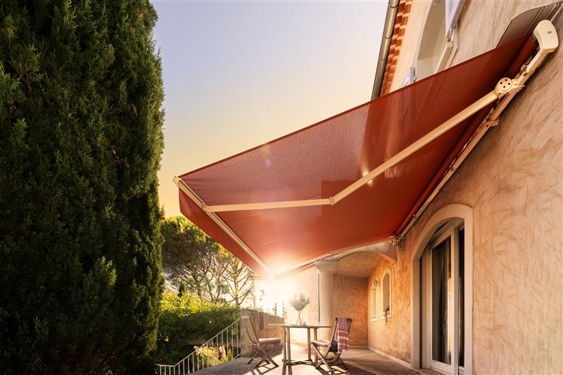 Store banne rouge équipé d’une toile Soltis 96 du Groupe Serge Ferrari, installé sur une façade extérieure.