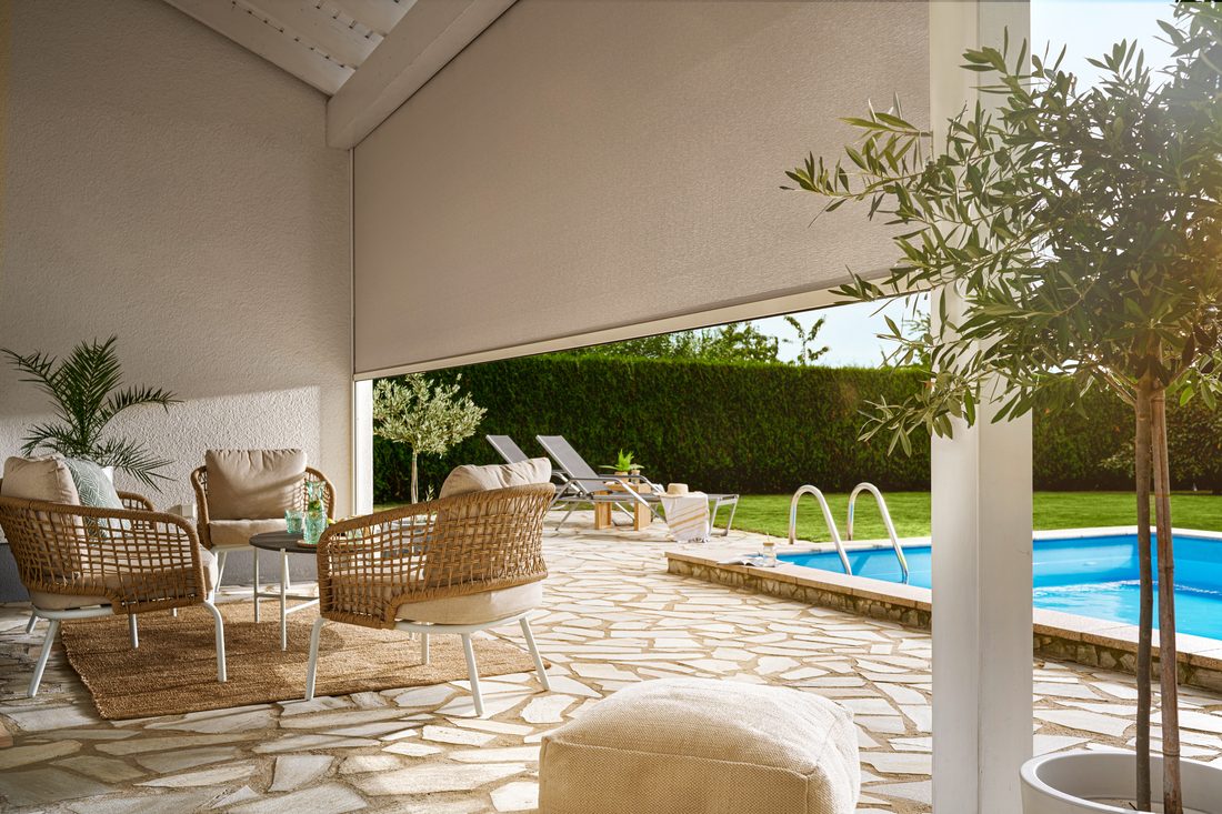 Terrasse ombragée avec store extérieur en membrane composite souple Serge Ferrari, offrant une protection solaire près d’une piscine.