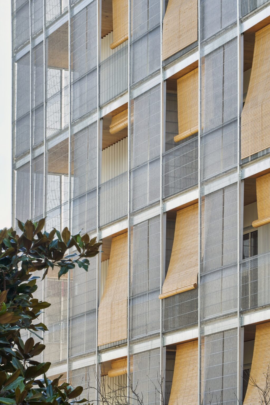 Détail façade bois et textile architectural Serge Ferrari sur immeuble résidentiel durable