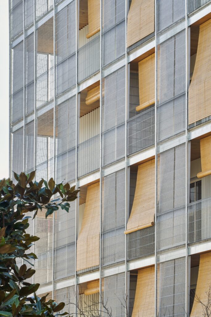 Détail façade bois et textile architectural Serge Ferrari sur immeuble résidentiel durable