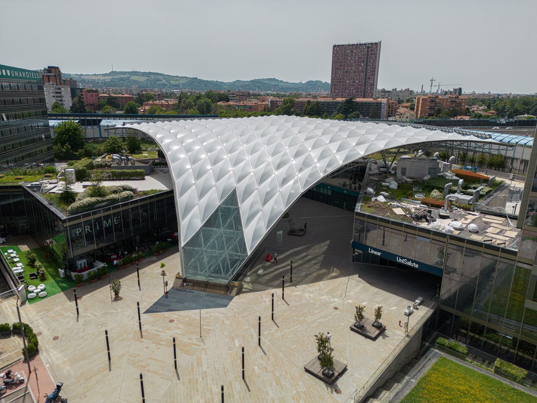 Canopée textile Vela couvrant l’esplanade au pied de la tour Unipol à Bologne