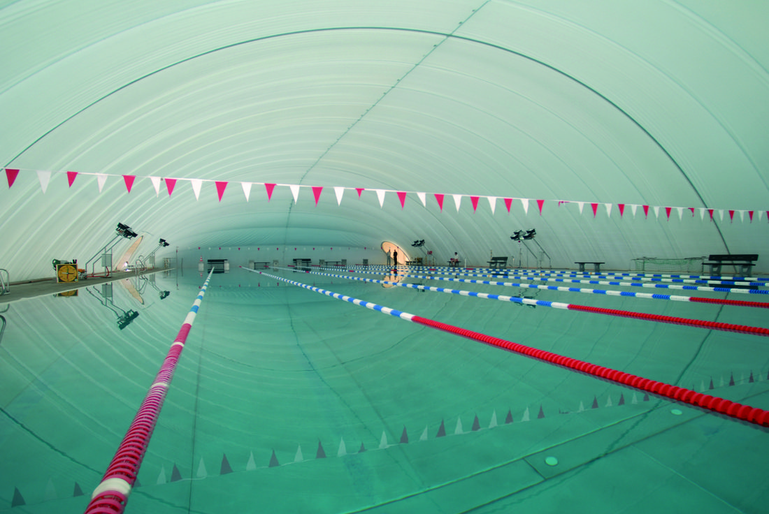 Piscine couverte par un dôme en membrane composite souple Serge Ferrari, offrant une couverture textile légère et lumineuse pour les équipements sportifs.