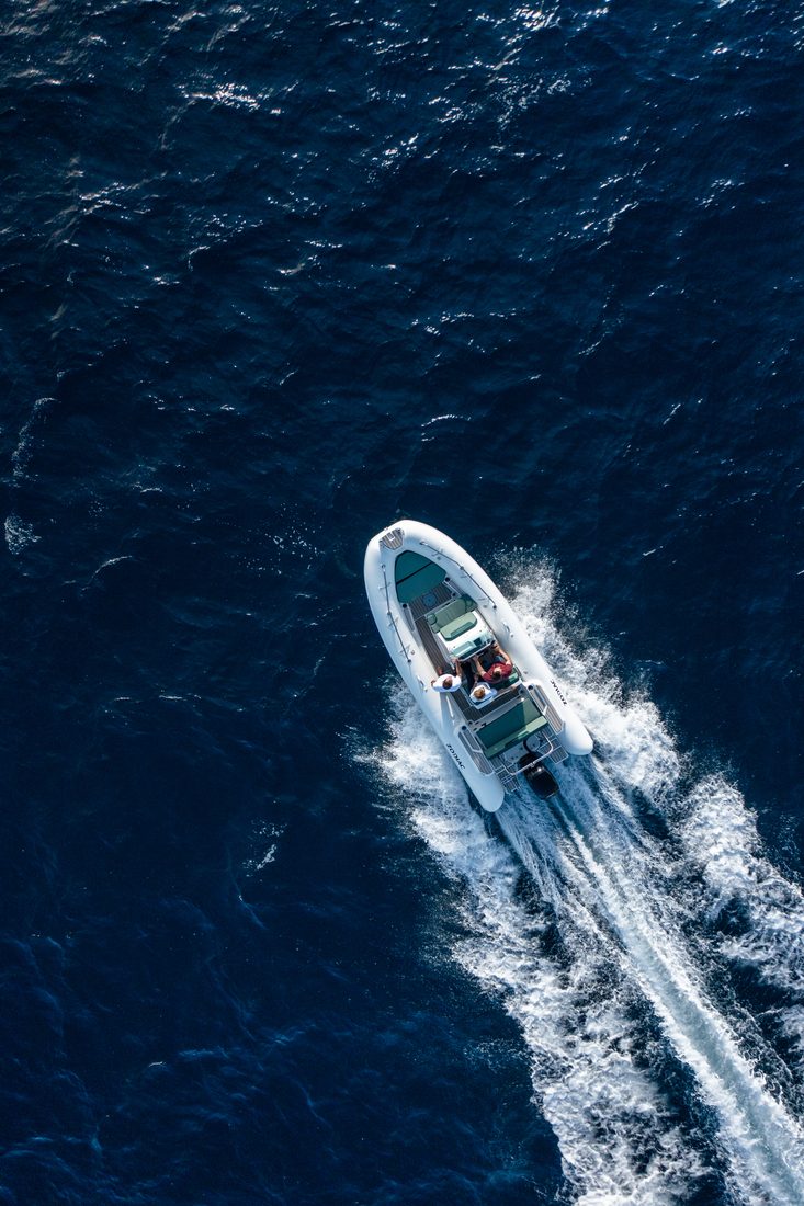 Vue aérienne d’un semi-rigide naviguant en mer, mettant en valeur ses flotteurs en membrane composite et son sillage.