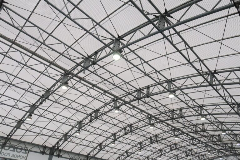 Toiture en membrane composite souple Serge Ferrari sur structure métallique, offrant une couverture légère et lumineuse pour un espace sportif.