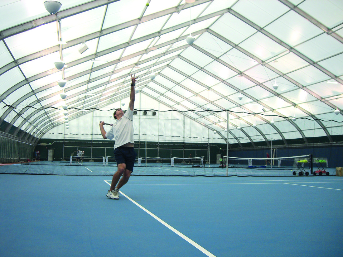 Terrain de tennis couvert par une membrane composite souple Serge Ferrari, offrant une structure lumineuse et résistante pour équipements sportifs.