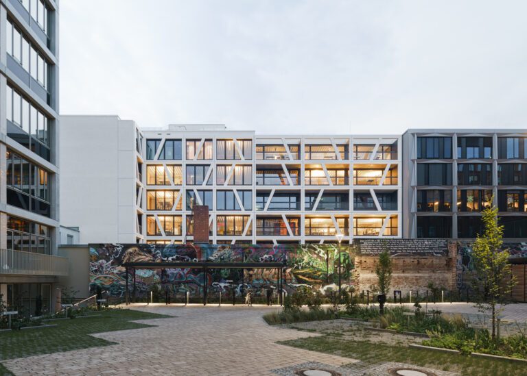 Cour intérieure d’un immeuble de bureaux à Berlin avec façade graphique et mur street art.