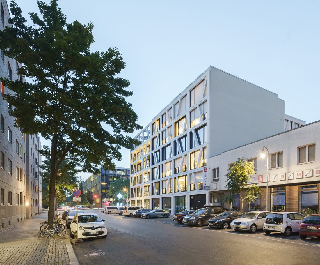 Immeuble de bureaux contemporain à Berlin avec façade graphique blanche au crépuscule.
