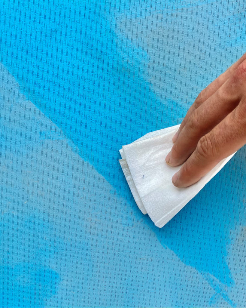 Main nettoyant une toile Soltis 96 avec une lingette, surface facile d’entretien