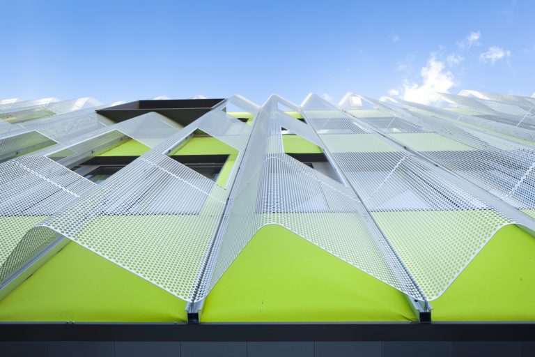 Membrane composite Serge Ferrari microperforée installée en façade architecturale, assurant protection solaire, gestion de la lumière et performance esthétique