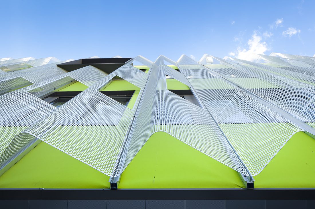 Membrane composite Serge Ferrari microperforée installée en façade architecturale, assurant protection solaire, gestion de la lumière et performance esthétique