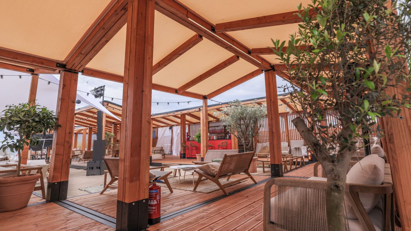 Interior view of a reusable woodbox unit with tensile membrane roof for temporary accommodation