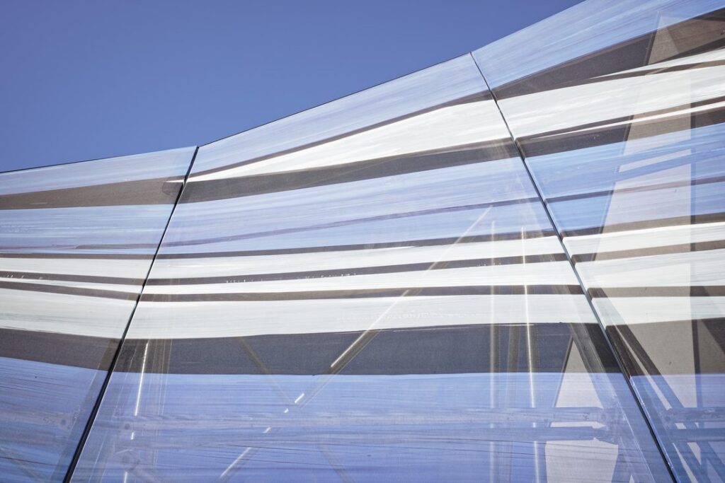 Façade imprimée avec motif imprimé en bandes horizontales, jouant sur la transparence et le contrôle de la lumière.