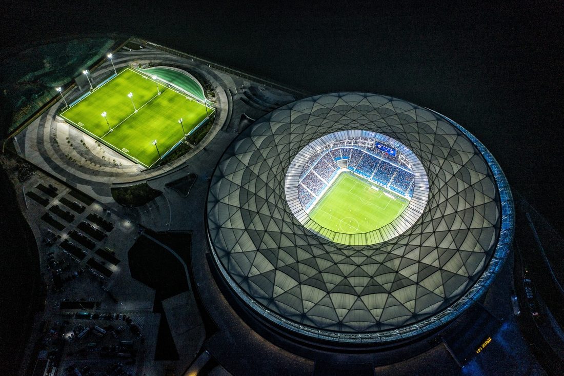 Vue aérienne nocturne du Dalian Suoyuwan Football Stadium avec toiture textile PTFE illuminée
